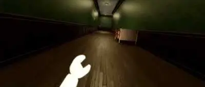 A dark hallway in The Manor, with wooden floors and green walls